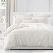 Adrianne Pearl duvet cover set in soft ivory with coordinating pillow shams on a white bed