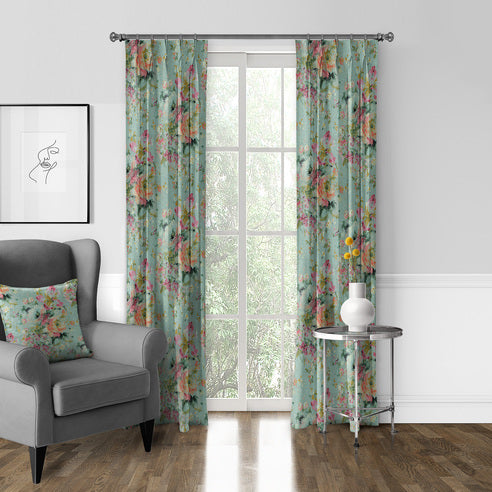 Blossom Eggshell floral drapery panels framing a tall window beside a grey armchair with a matching floral cushion.