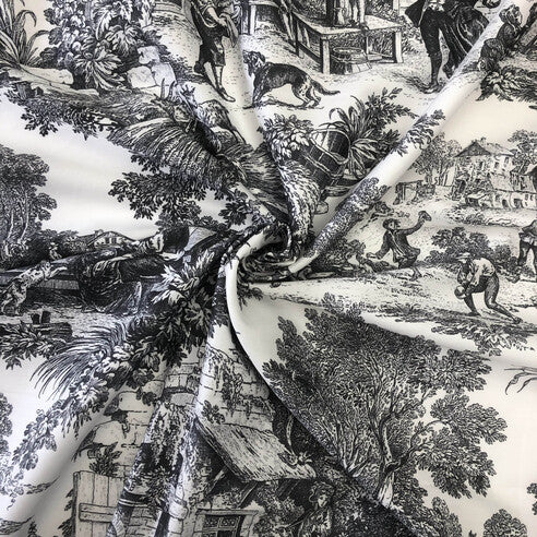 Close-up of a ebony and ivory patterned fabric with classical scenes.