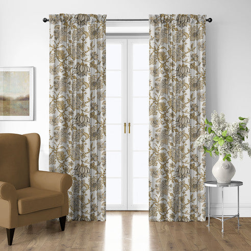 Bronte Gold pole top floral drapery panels framing white French doors, with a gold-toned armchair and flower-filled vase nearby.