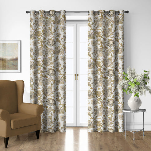 Bronte Gold grommet top floral drapery panels framing white French doors beside a gold-toned armchair.