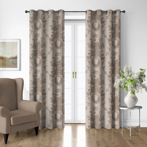 Country Lane Natural grommet top patterned drapery panels framing white French doors beside a taupe armchair.