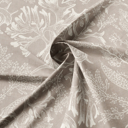Close-up of Shellabrate Natural fabric showing ivory seashell and coral motifs on a beige background
