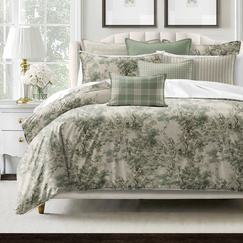 Dolce duvet cover styled on bed showing serene blue forest pattern with neutral beige backdrop and decorative pillows