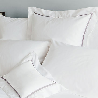 Close-up of St. Genève Capri Clair white sateen pillowcases showing elegant grey satin stitch border detail