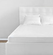St. Genève Allergy Mattress Encasement fitted on a modern white upholstered bed with clean minimal styling