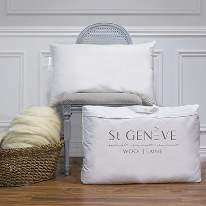 St. Genève Piatra wool pillow with branded packaging reading Wool Laine, styled on a chair with a basket of raw wool