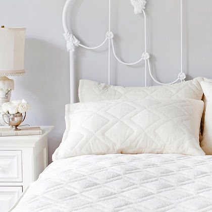 St. Dormeir® Pillow Protector on a bed with white iron headboard, luxury bedroom setting