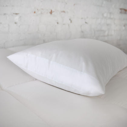 St. Genève Absolute Pillow Protector on a single white pillow, close-up lifestyle shot