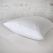 St. Genève Absolute Pillow Protector on a single white pillow, close-up lifestyle shot