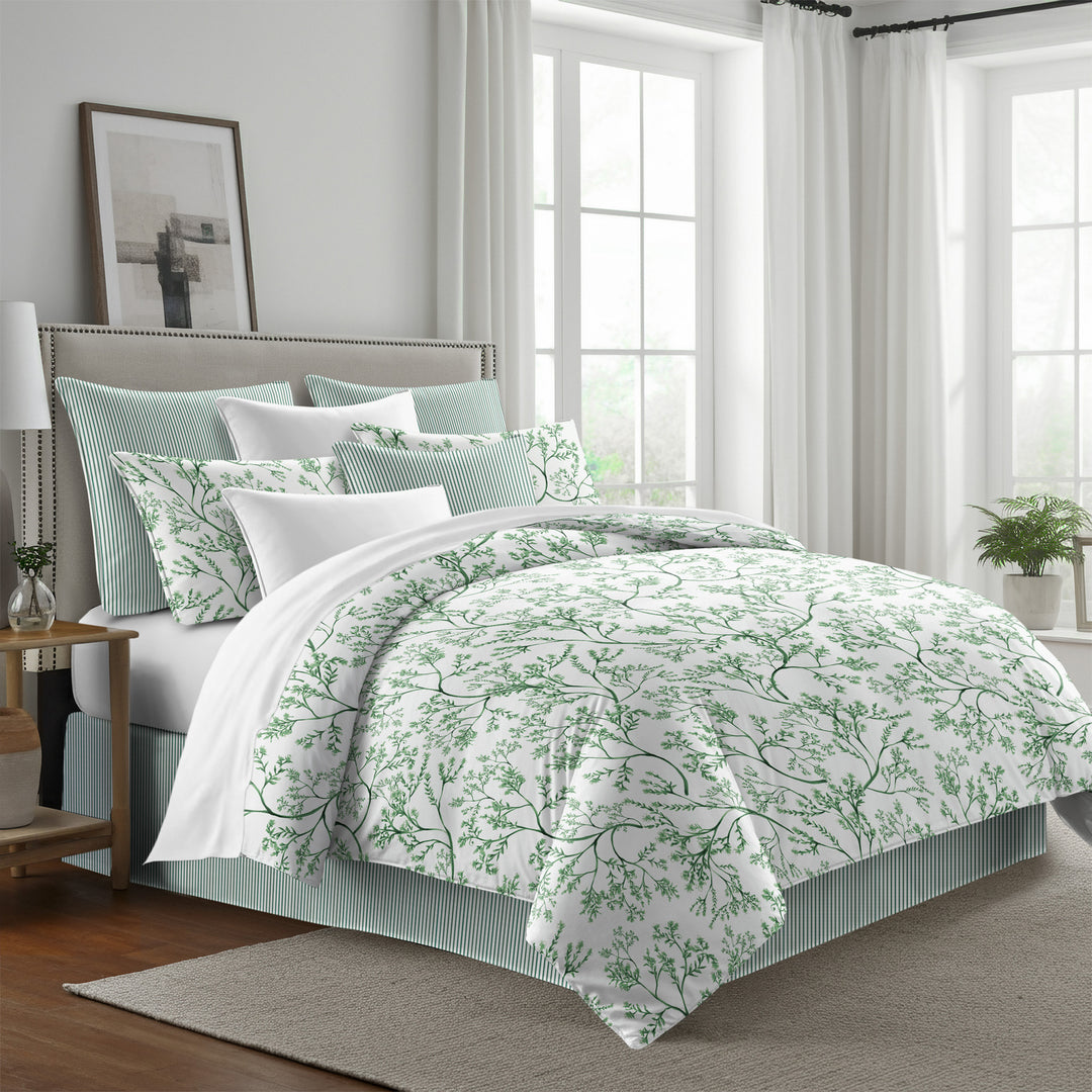 Tinsley comforter set with green leafy branches on antique white, styled with matching shams and green striped pillows