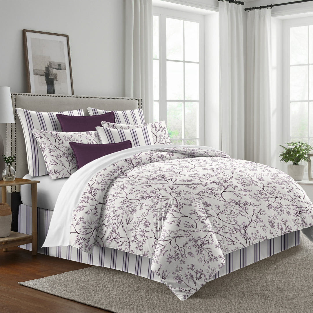 Tinsley comforter set with plum leafy branches on antique white, styled with matching shams and deep purple accent pillows