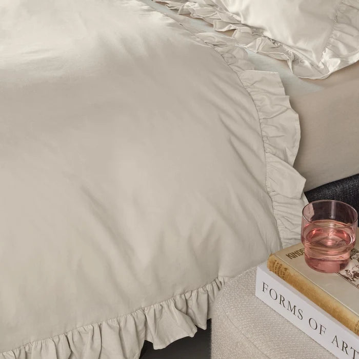 edge detail: Armance natural cotton duvet cover showing gathered ruffle trim along the edge and corner