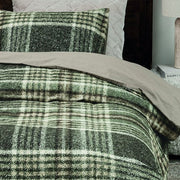 closer view: Close-up of Elliot green plaid flannel duvet cover with a plain beige reverse and matching pillow