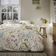 full bed: Melodie cotton duvet cover with blue, pink and yellow wildflowers on a cream background, styled with matching pillows