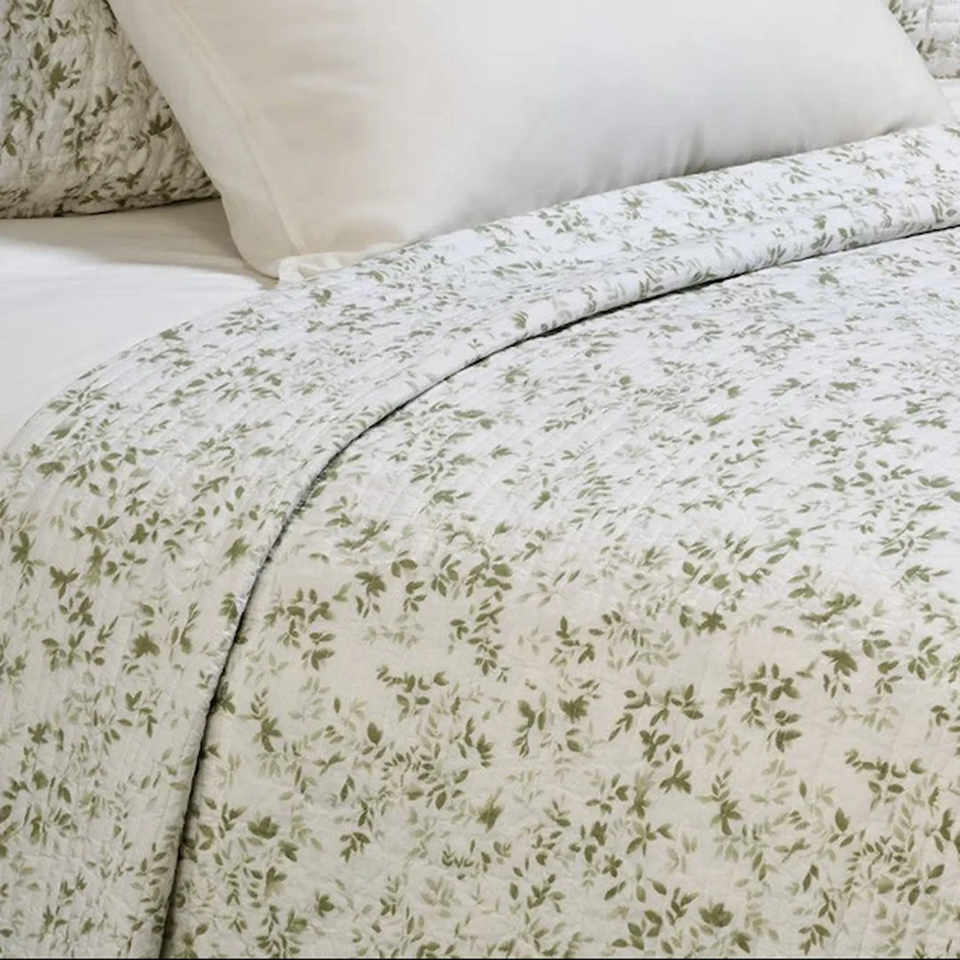 Close-up of Marjolaine quilt featuring delicate sage leaf print on white 100% cotton shell – available in Twin, Double-Queen, King, and Super King
