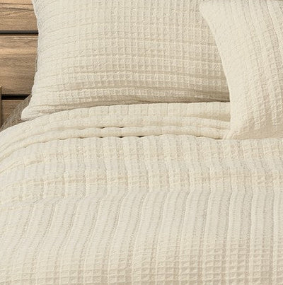 Close-up of the Spirit cream cotton quilt and pillow sham showing the waffle texture.