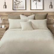 Spirit cream waffle cotton quilt on a bed with coordinating cream pillows and a wooden headboard.