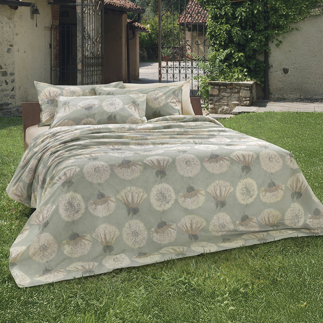 Tara dandelion print duvet cover and shams styled on a bed outdoors in a garden setting – 100% long-staple cotton by Cuddle Down
