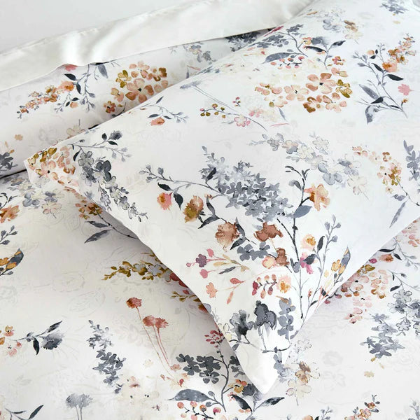 Camille floral duvet cover set styled on a bed, showcasing the watercolor print and premium cotton sateen finish in a modern bedroom