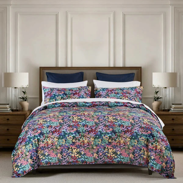 Florisse duvet cover set with a multicoloured floral print and matching pillowcases styled on a bed.