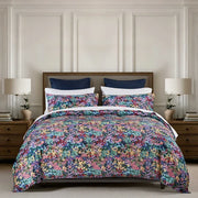 Florisse duvet cover set with a multicoloured floral print and matching pillowcases styled on a bed.