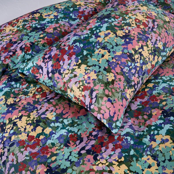 Close-up of Florisse pillowcase and duvet cover showing the colourful painterly floral pattern.