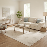 Diamond lattice trellis area rug in ivory and soft beige tones with subtle geometric pattern styled in a family room under a coffee table and sofa — modern classic design