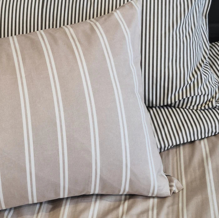 Martini olive striped cotton duvet cover styled on a bed with matching pillows