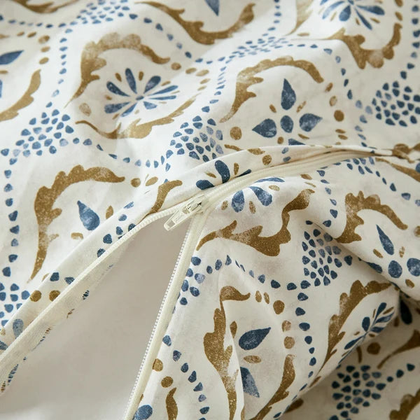 Close-up of the concealed zipper on the Motif duvet cover with blue and olive green patterned fabric.
