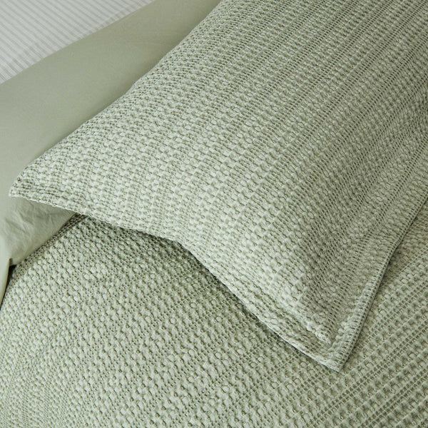Close-up of Solene Seafoam pillow sham and duvet cover showing the waffle texture.