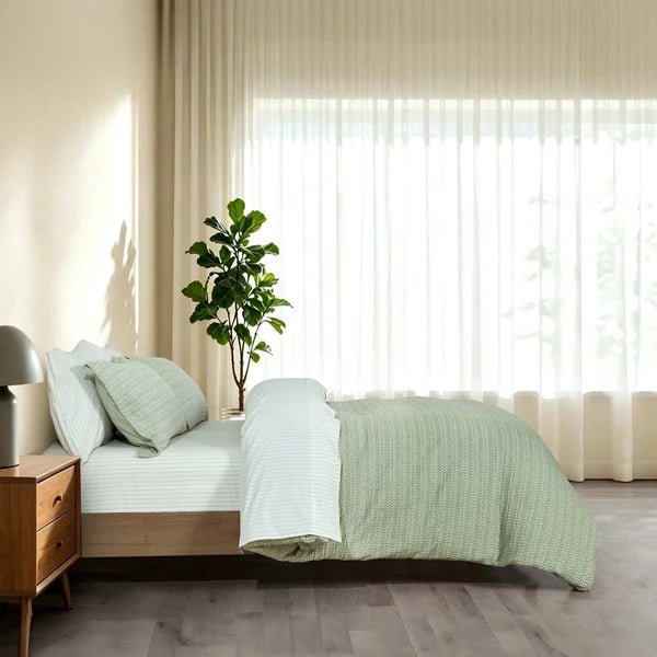 Side view of Solene Seafoam duvet cover with a folded-back edge and matching pillow shams.