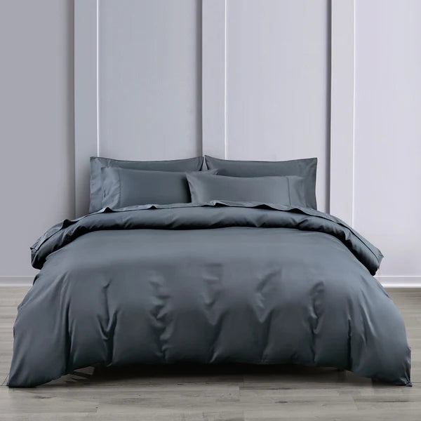 Gray bed skirt  se on a bed against a light gray panel