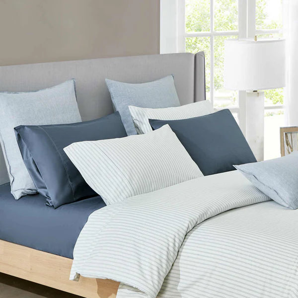 Vale Shadow duvet cover set styled on bed showing blue pinstripe pattern