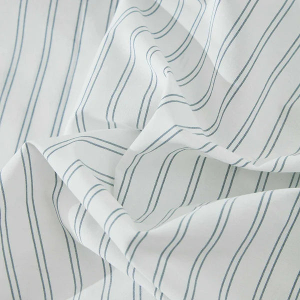 Close-up of Vale Shadow duvet cover fabric showing yarn-dyed blue pinstripe pattern on cotton percale